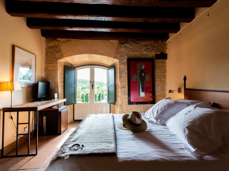 Rustikales Schlafzimmer, Steinwände, Holzbalken, gemütliches Bett, Hotelzimmer